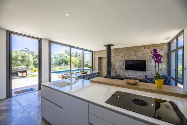 Cuisine ouverte avec îlot et vue sur la piscine