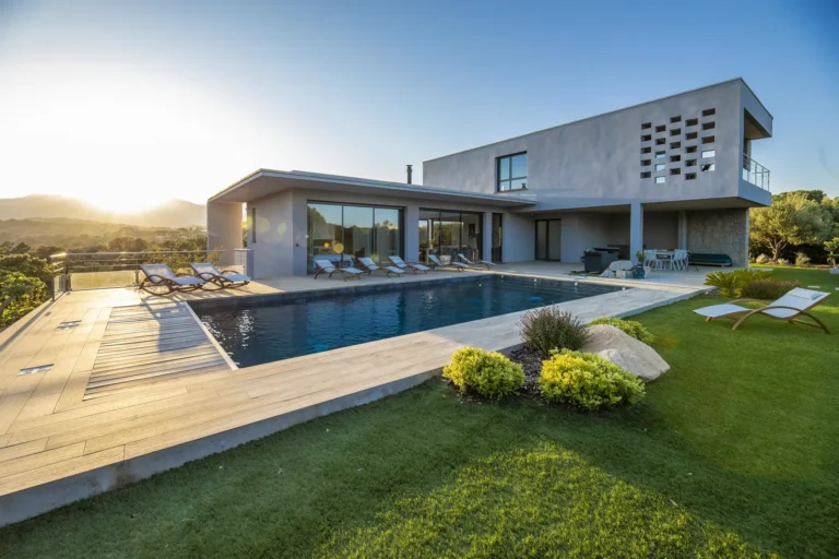 Villa contemporaine avec piscine et pelouse au coucher du soleil