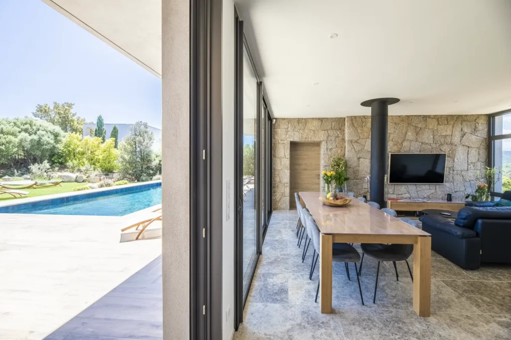 Salle à manger en bois ouverte sur la piscine