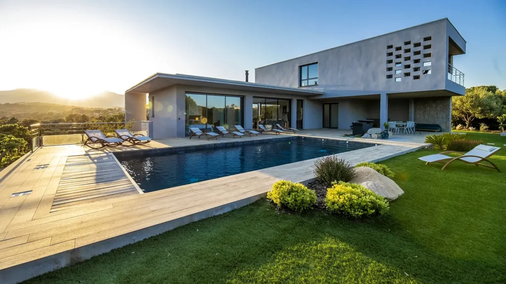 La piscine du Petit Pinarello au coucher du soleil, transats et façade de la villa