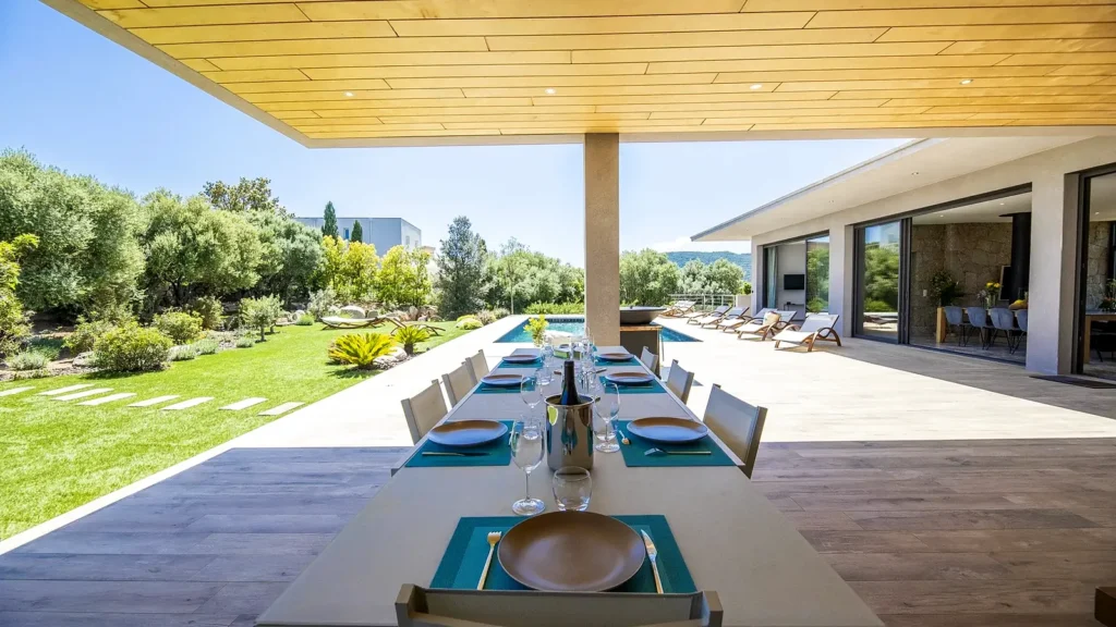 La grande table extérieure Grande table extérieure dressée pour un repas en groupe, au bord du jardin
