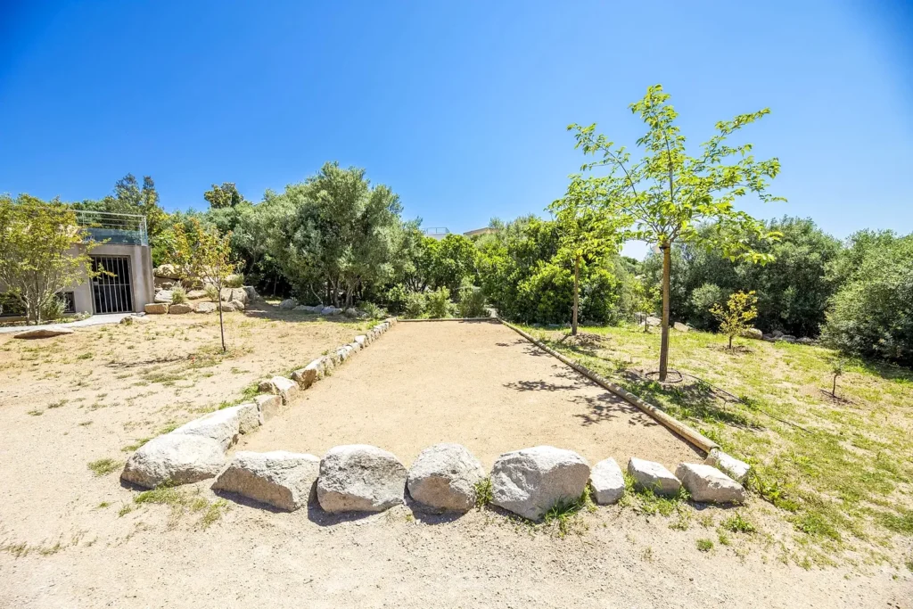 Terrain de pétanque dans le jardin de la villa, entouré de maquis